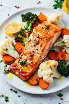 salmon, cauliflower, carrots and broccoli on a white plate