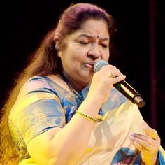 a woman in a sari singing into a microphone