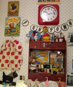 a red bookcase with lots of toys on it and a clock above it in the corner