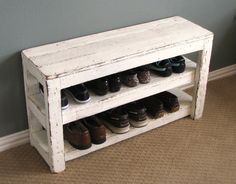 a white shoe rack with shoes on it in a room next to a gray wall