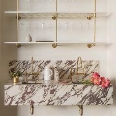 a marble counter top with gold faucets and brass fixtures in a kitchen area