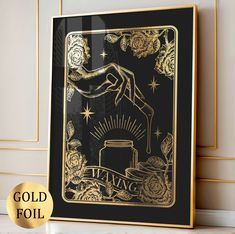 a gold foiled playing card on a black background with roses and starbursts