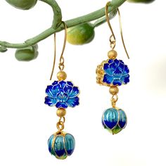 "\"CLOISONNE' DROPS\"-my fun, pretty earrings have cloisonné' enameled gold flower beads and a lotus flower drop in shades of royal blue, turquoise, green, & yellow. These beautiful 2 sided beads are accented with gold stardust beads & hang from gold French ear wires. *The earrings measures 2.125\" long from the earlobe & .50\" wide *I am happy to ship multiple items together-please feel free to contact me *I make all of my pieces by hand and many are one-of-a-kind. I start by laying out all of Gold Flower Earrings With Dangling Beads As Gift, Bohemian Blue Flower Earrings With Dangling Beads, Gold Earrings With Flower Charm And Enamel, Gold Earrings With Flower Charm In Enamel, Bohemian Blue Flower Earrings, Gold Enamel Earrings With Flower Charm, Gold Flower-shaped Jewelry With Dangling Beads, Gold Flower-shaped Earrings With Dangling Beads, Bohemian Enamel Drop Earrings