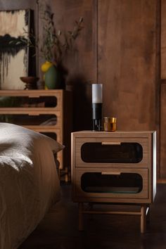 a wooden nightstand sitting on top of a bed