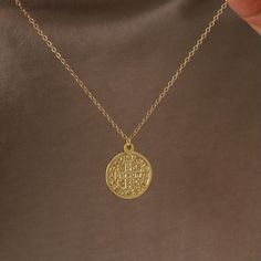 This gold pendant necklace features a medallion which says "Virtvte Tva Fiat Pax In" (“May there be peace in your strength") on the front. Enjoy two unique designs from front and back. Coin size: 18 mm, thickness: 1.5 mm Spring ring clasp 18K gold plated coin 14K gold filled chain Nickel-free Spiritual Medallion Necklace Tarnish Resistant, Spiritual Gold-plated Medallion Necklace With Round Pendant, Gold Coin Pendant Necklace For Blessing, Spiritual Gold Plated Round Medallion Necklace, Symbolic Medallion Coin Necklace Tarnish Resistant, Spiritual Gold Plated Medallion Necklace, Blessing Coin Pendant Medallion Jewelry, Spiritual Tarnish-resistant Coin Necklace Gift, Gold Coin Necklace With Large Symbolic Pendant