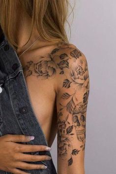 a woman with tattoos on her arm and shoulder is holding an old pair of jeans