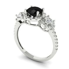 a black diamond ring with three stones on the side and an oval center stone in the middle