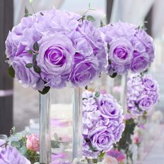 purple flowers are arranged in vases on a table