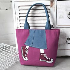 a pink purse with a pair of red converse shoes on the front and blue bottom