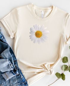 If you like this design, check out our entire shop at https://www.etsy.com/shop/blondiedogdesigns/?etsrc=sdt for many more styles! Wear this daisy shirt to brighten your mood year 'round!  This tee is perfect on it's own or under a cardigan- either way it's too cute!  About this item: This classic unisex jersey short sleeve tee fits like a well-loved favorite. Soft cotton and quality print make users fall in love with it over and over again. These t-shirts have-ribbed knit collars to bolster sha Daisy Clothes, Trendy Womens Shirts, Daisy Shirt, Baggy T-shirt, Sunflower Shirt, Botanical Shirt, Sunflower Print, See You Soon, Cute Woman