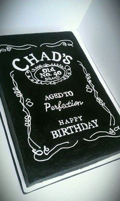 a black and white birthday cake with the words chad's written in white on it