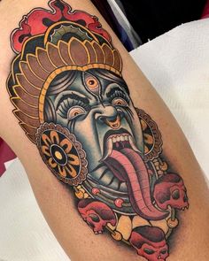 a tattoo with an image of a demon on the side of his arm and tongue out