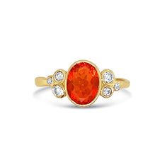 a gold ring with an orange stone and diamonds