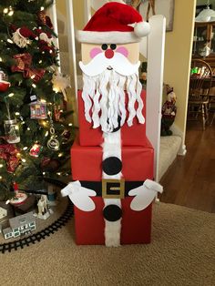 a cardboard santa clause sitting in front of a christmas tree