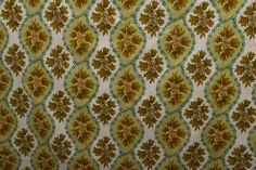 an old wallpaper with gold and green flowers on it's surface, as well as the background