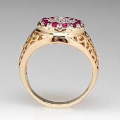 This pretty ruby and diamond ring is centered with a cluster setting accented with seven (7), prong set, round brilliant cut diamonds, bordered with twelve (12), prong set, round mixed cut natural rubies. The shoulders of the ring feature a pierced design. The ring measures 15.6mm at the top, rises 6.9mm above the finger, tapering to 3.8mm wide and 1.4mm thick at the base of the shank. It is currently a size 9.25. Two of the rubies have small unnoticeable chips. Diamond Cluster Ruby Ring With Diamond Accents, Ruby Cluster Ring With Rose Cut Diamonds, Round Ruby Cluster Ring With Rose Cut Diamonds, Classic Ruby Ring With Diamond Accents Cluster, Classic Ruby Ring With Diamond Accents In Cluster Shape, Red Cluster Ring With Rose Cut Diamonds, Ruby Ring With Rose Cut Diamonds And Cubic Zirconia, Ruby Rings With Single Cut Diamonds, Ruby Rings With Round Cut Single Diamonds