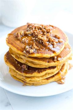 stack of pancakes topped with walnuts and syrup