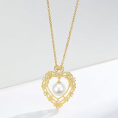 Vintage Hollow Heart Freshwater Pearl Pendant Necklace This elegant Vintage Hollow Heart Freshwater Pearl Pendant Necklace features a 7-8mm pearl set in a gold vermeil pendant. The timeless design and high-quality materials make it a perfect addition to any jewelry collection. Add a touch of vintage charm to your style while enjoying the natural beauty and elegance of freshwater pearls. Necklace Chain, material 925 sterling silver Length: 40cm with an extension of 5cm Product Information Pearl T Elegant Gold Plated Heart Pendant Necklace, Exquisite Gold Pearl Necklace For Anniversary, Vintage Heart Pendant Jewelry With Pearl, Gold Pearl Jewelry With Heart Charm, Gold Heart Pendant Necklace For Formal Occasions, Heart-shaped Yellow Gold Jewelry With Pearl Charm, Yellow Gold Heart Jewelry With Pearl Charm, Gold Pendant Heart Necklace For Formal Occasions, Elegant Gold-plated Yellow Gold Heart Necklace