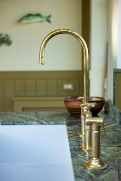 a gold faucet sitting on top of a kitchen counter next to a sink