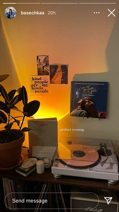 a record player sitting on top of a table next to a plant