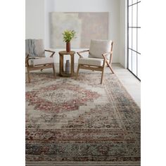 a living room with two chairs and a rug