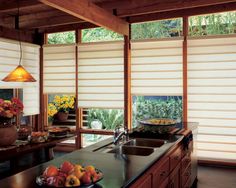 an image of a kitchen setting with blinds in the window and fruit on the counter