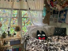 a bed room with a neatly made bed and a cat stuffed animal on top of it