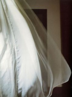 a black and white photo of an unmade bed with the sheets pulled back over it