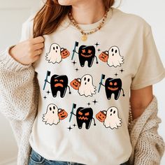 a woman wearing a t - shirt with ghost and pumpkins on it