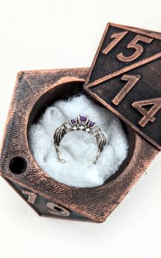 a ring is sitting in a box with some snow around it and numbers on the inside