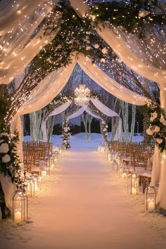 an outdoor wedding venue decorated with white drapes and lights