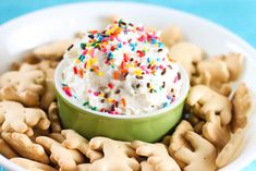 a bowl filled with cookies and sprinkles on top of a blue table cloth