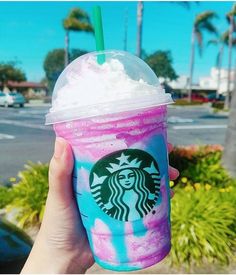 a hand holding up a starbucks drink with pink and blue swirl