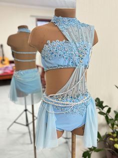 two mannequins with blue dresses on display