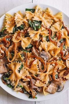 a white plate topped with pasta and mushrooms