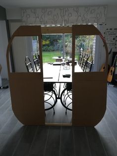 an open cardboard box sitting on top of a floor next to a dining room table