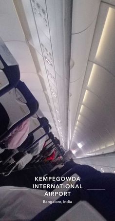 the inside of an airplane with luggage on it's side and text that reads kemppegowda international airport