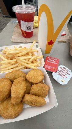 chicken nuggets and french fries on a table next to a cup of ketchup