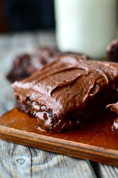 chocolate cake on a wooden plate with a glass of milk