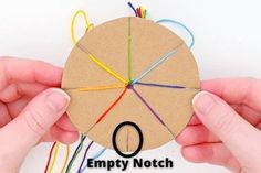 two hands holding up a piece of cardboard with colored yarn on it and the words empty not