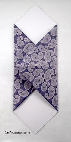 an origami tie with white and blue designs on it