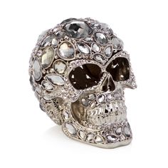 a silver skull with lots of crystals on it's face and eyes, sitting in front of a white background