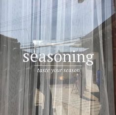 there is a window with the words seasoning written on it and an image of a man walking down the street