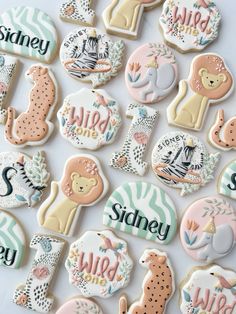 the cookies are decorated with different types of animals and letters on them, all in pastel colors