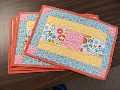 four placemats are sitting on a wooden table