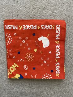 a red bandana with an image of a unicorn on it that says, save the peace and win