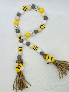 a yellow and gray beaded necklace with tassels