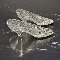 two clear shoes sitting on top of a black table