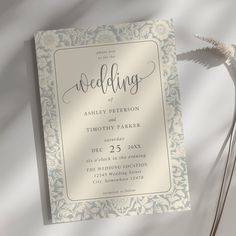 the wedding card is next to a flower