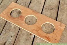 a wooden object with three holes in it